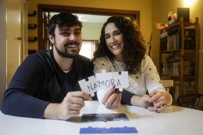 PORTO ALEGRE, RS, BRASIL, 09-06-2026: O casal de namorados, a atriz e professora Marina Greve, 27, e o ator e produtor Henrique Strieder, 26, em casa, no bairro São João. Ele fez o pedido dela em namoro através de um quebra-cabeça com uma foto dos dois. Foto: Mateus Bruxel/Agência RBSIndexador: MATEUS BRUXEL<!-- NICAID(16302796) -->