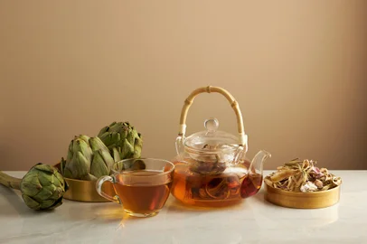 Artichoke teapot in golden dish with light brown background for product advertising , front view , food and drink contentFonte: 472739612<!-- NICAID(15537067) -->