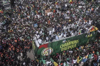This aerial view shows Senegal's Football Team players as they ride on a bus past supporters during a trophy parade in the streets of Dakar on January 20, 2026 as they celebrate Senegal winning the Africa Cup of Nations (CAN) that was hosted in Morocco. Senegal won the Africa Cup of Nations in Rabat on January 18, 2026, Pape Gueye's extra-time winner sinking hosts Morocco 1-0 after a chaotic final that saw the eventual champions storm off the pitch late in the game. (Photo by Mamadou Aliou Diallo / AFP)<!-- NICAID(16207620) -->