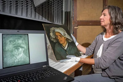A handout picture released by the National Galleries of Scotland on July 14, 2022 shows senior conservator Lesley Stevenson viewing "Head of a Peasant Woman" alongside an X-ray image of a hidden self-portrait of Dutch painter Vincent Van Gogh in Edinburgh. - A gallery in Scotland said it was "thrilled" to announce the discovery of a previously unknown self-portrait of Vincent Van Gogh, with his ear intact, hidden behind another painting. The portrait was found on the back of the canvas of the Dutch post-Impressionist's 1885 work "Head of a Peasant Woman", covered by layers of glue and cardboard. (Photo by Neil Hanna / National Galleries of Scotland / AFP) / RESTRICTED TO EDITORIAL USE - MANDATORY MENTION OF THE ARTIST UPON PUBLICATION - MANDATORY CREDIT "AFP PHOTO / NEIL HANNA / NATIONAL GALLERIES OF SCOTLAND" -  TO ILLUSTRATE THE EVENT AS SPECIFIED IN THE CAPTION - NO MARKETING NO ADVERTISING CAMPAIGNS - DISTRIBUTED AS A SERVICE TO CLIENTS / Editoria: ACELocal: EdinburghIndexador: NEIL HANNASecao: paintingFonte: National Galleries of ScotlandFotógrafo: Handout<!-- NICAID(15148593) -->