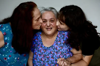 Porto Alegre, RS, Brasil — Com maior longevidade, pessoas com síndrome de Down colocam em pauta quem decide sobre suas vidas, entre autonomia, família e cuidado, em um debate cada vez mais urgente. FOTO; JEFF BOTEGA/AG RBSEsquerda Lair Soares, no meio a com síndrome de Down Maria Isabel e a Caroline.<!-- NICAID(16248456) -->