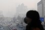 A woman wearing a face mask walks on an overpass in Beijing on January 16, 2014.  China's capital was shrouded in thick smog on January 16, cutting visibility down to a few hundred metres as a count of small particulate pollution reached more than 20 times recommended levels.        AFP PHOTO / WANG ZHAO<!-- NICAID(10149074) -->