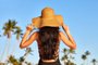 Woman in sunhat on a beachUma mulher com um chapéu de sol de pé sobre um céu azul. Foto: kobeza / stock.adobe.comIndexador: Dmitry KobezaFonte: 109338007<!-- NICAID(14975474) -->
