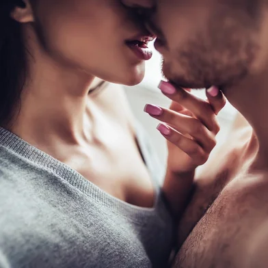 Close-up of young romantic couple is kissing and enjoying the company of each other at home.