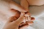 Father and mother holding small newborn baby hand, closeup.Indexador: NATALIA BOSTANFonte: 441151021<!-- NICAID(15736247) -->