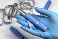 Hands in surgical gloves holding Ozempic Insulin injection pen for diabetics.Hands in blue surgical gloves holding Ozempic Insulin injection pen for diabetics. Fonte: 726555519<!-- NICAID(16302717) -->