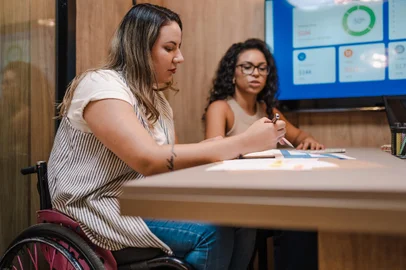 Empresária Brasileira cadeirante em reunião com sua sócia Latina negra no BrasilIndexador: Cristiano BabiniFonte: 617517824<!-- NICAID(15513044) -->