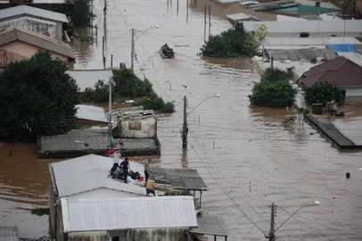 CANOAS, RS, Brasil, 04-05-2024: Pessoas resgatadas por equipe de bombeiros e exército de cima dos telhados das casas alagadas no bairro Rio Branco, em Canoas. Sete resgatados foram levados para o hospital da Ulbra. Foto: Mateus Bruxel / Agência RBS<!-- NICAID(15754362) -->