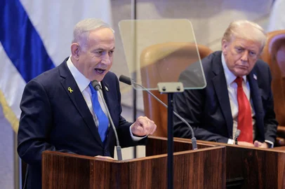 Israeli Prime Minister Benjamin Netanyahu (L) speaks as US President Donald Trump listens during an address to the Israeli parliament, the Knesset, in Jerusalem on October 13, 2025. Hamas handed over the 20 surviving Israeli hostages on October 13 under a ceasefire agreement, as the US president and other world leaders geared up for a summit on Gaza. The releases are part of a ceasefire agreement brokered by the US president, with Israel due in return to free nearly 2,000 detainees held in its jails in exchange. (Photo by Chip Somodevilla / POOL / AFP)<!-- NICAID(16144654) -->
