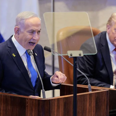 Israeli Prime Minister Benjamin Netanyahu (L) speaks as US President Donald Trump listens during an address to the Israeli parliament, the Knesset, in Jerusalem on October 13, 2025. Hamas handed over the 20 surviving Israeli hostages on October 13 under a ceasefire agreement, as the US president and other world leaders geared up for a summit on Gaza. The releases are part of a ceasefire agreement brokered by the US president, with Israel due in return to free nearly 2,000 detainees held in its jails in exchange. (Photo by Chip Somodevilla / POOL / AFP)<!-- NICAID(16144654) -->