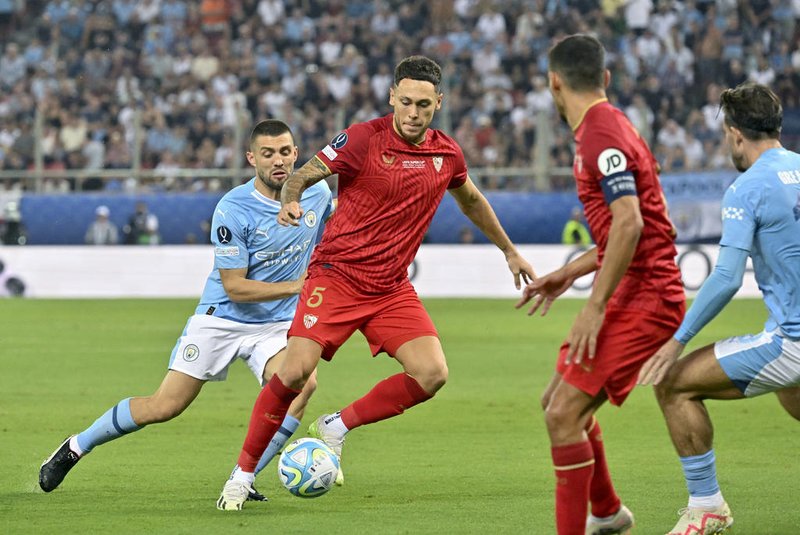 Sevilla's Argentinian forward #05 Lucas Ocampos (2L) runs with the ball during the 2023 UEFA Super Cup football match between Manchester City and Sevilla at the Georgios Karaiskakis Stadium in Piraeus on August 16, 2023. (Photo by Louisa Gouliamaki / AFP)Editoria: SPOLocal: PiraeusIndexador: LOUISA GOULIAMAKISecao: soccerFonte: AFPFotógrafo: STF<!-- NICAID(15512096) -->
