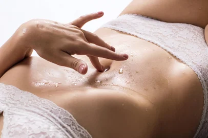 Sexy woman is lying and touching her belly.Beautiful sexy woman is lying and touching her belly.Indexador: Kotin DmitriiFonte: 178792539<!-- NICAID(15156511) -->