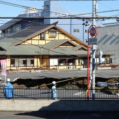 This photo shows a general view of a collapsed road at a prefectural road intersection, in the city of Yashio, Saitama Prefecture on January 30, 2025. Japanese authorities have asked 1.2 million people to cut back on showers and laundry as they seek to recover a truck driver stuck in a sinkhole for a third day, officials said on January 30. (Photo by JIJI Press / AFP) / Japan OUT<!-- NICAID(15965754) -->