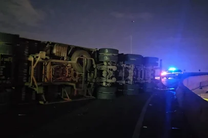 PORTO ALEGRE, RS, BRASIL - 11/06/2025 - Caminhão tomba em alça da ponte nova do Guaíba; carga de madeira para serragem fica espalhada<!-- NICAID(16057761) -->
