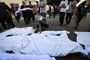 The wrapped bodies of those killed in Israeli bombardment are brought into the courtyard of the Shuhada Al-Aqsa hospital, to be take for burial in Deir el-Balah, in the central Gaza Strip on November 6, 2023, amid the ongoing battles between Israel and the Palestinian group Hamas. (Photo by Mahmud HAMS / AFP)<!-- NICAID(15588820) -->