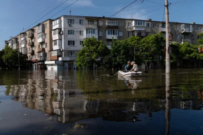 Ukrainian security forces transport local residents in a boat during an evacuation from a flooded area in Kherson on June 7, 2023, following damages sustained at Kakhovka hydroelectric power plant dam. Ukraine was evacuating thousands of people on June 7 after an attack on a major Russian-held dam unleashed a torrent of water, inundating two dozen villages and sparking fears of a humanitarian disaster. (Photo by ALEKSEY FILIPPOV / AFP)<!-- NICAID(15449773) -->