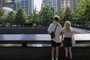 A couple stands before the National September 11 Memorial, marking the site of the south tower at the World Trade Center in New York, on September 8, 2021. - The remains of two more victims of 9/11 have been identified, thanks to advanced DNA technology, New York officials announced on September 7, 2021, just days before the 20th anniversary of the attacks. The office of the city's chief medical examiner said it had formally identified the 1,646th and 1,647th victim of the al-Qaeda attacks on New York's Twin Towers which killed 2,753 people. (Photo by Angela Weiss / AFP)<!-- NICAID(14885088) -->