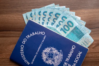 Brazilian document work and social security ( Carteira de Trabalho e Previdencia Social) with brazilian moneyBrazilian document work and social security ( Carteira de Trabalho e Previdencia Social) with brazilian moneyIndexador: @rpcast_photoFonte: 248078883<!-- NICAID(14636836) -->