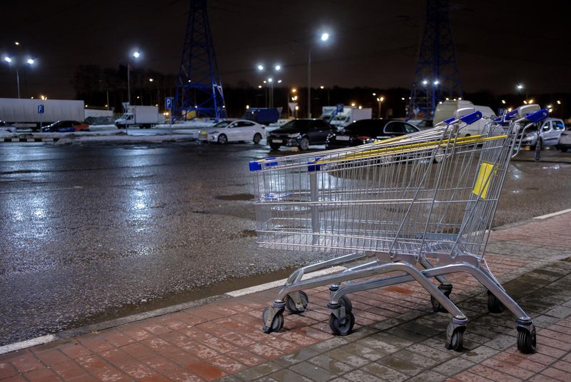 Empty blue and yellow shopping baskets next to a shop at night.Carrinho de supermercado. Foto: Nekrasov / stock.adobe.comIndexador: Nekrasov EvgenyFonte: 489742243<!-- NICAID(15739389) -->