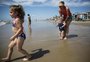 Sol, tempo firme e primeira vez com os pés no mar: veranistas aproveitam a praia de Capão da Canoa