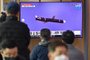 People watch a television screen showing a news broadcast with file footage of a North Korean missile test, at a railway station in Seoul on January 25, 2022, after North Korea fired two suspected cruise missiles according to the South's military. (Photo by Jung Yeon-je / AFP)<!-- NICAID(14997844) -->