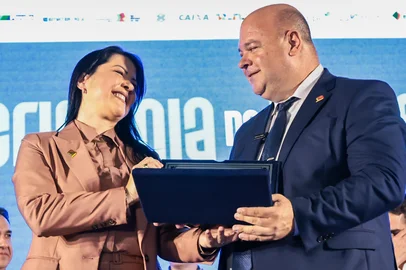 IMBÉ, RS – 30.04.2026 – O governador Eduardo Leite participou da cerimônia de posse do Conselho de Administração da Federação das Associações de Municípios do Rio Grande do Sul (Famurs) para a gestão 2026/2027, realizada no Parque Municipal de Eventos, em Imbé. O ato reuniu autoridades estaduais, lideranças municipais e representantes de entidades para marcar a transição da gestão e o alinhamento de pautas prioritárias para os municípios gaúchos. Na foto, ex-presidente Adriane Perin transmite cargo para Ique Vedovato.Crédito: Mauricio Tonetto / Secom<!-- NICAID(16276626) -->