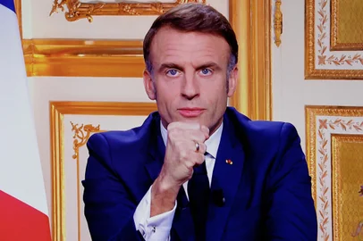 French President Emmanuel Macron is seen on monitors in a control room at AFP headquarters as he addresses the nation during a televised broadcast from the presidential Elysee Palace, on the day of the Prime Minister's resignation on December 5, 2024, following the parliamentary defeat one day prior, that forced his government to step down. President Emmanuel Macron on December 5, 2024, sought a new prime minister to prevent France from sliding deeper into political turmoil after Prime Minister's government was ousted in a historic no-confidence vote in parliament. The vote was the first successful no-confidence action since a defeat for Georges Pompidou's government in 1962, when Charles de Gaulle was president. (Photo by Ludovic MARIN / AFP)Editoria: POLLocal: ParisIndexador: LUDOVIC MARINSecao: governmentFonte: AFPFotógrafo: STF<!-- NICAID(15929572) -->