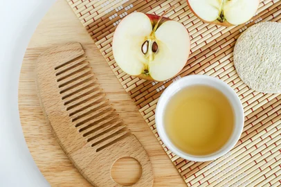 Apple juice (vinegar) and wooden hair brush. Ingredients for preparing homemade hair mask or face toner. Natural beauty treatment recipe and zero waste concept. Top view, copy space. Foto: kazmulka / stock.adobe.comIndexador: kazmulkaFonte: 340267031<!-- NICAID(16261958) -->