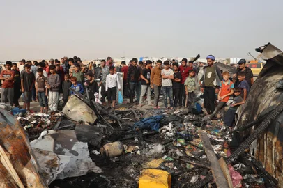 Palestinians gather at the site of an Israeli strike on a camp for internally displaced people in Rafah on May 27, 2024, amid ongoing battles between Israel and the Palestinian Hamas militant group. (Photo by Eyad BABA / AFP)Editoria: WARLocal: RafahIndexador: EYAD BABASecao: armed conflictFonte: AFPFotógrafo: STR<!-- NICAID(15774390) -->