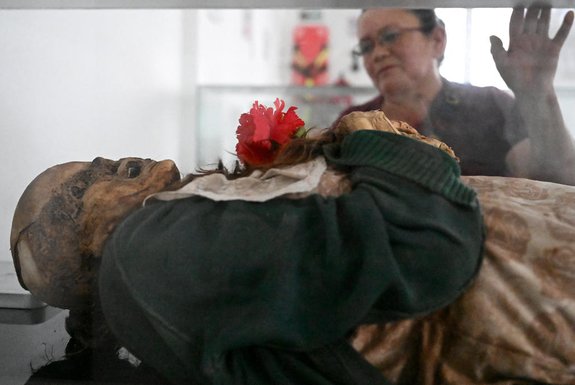 Local resident Clovisnerys Bejarano visits her mother Saturnina Torres, who died in 1993 and was exhumed in 2001, and now rests in the museum of mummies at the Jose Arquimedes Castro mausoleum, located at the cemetery in San Bernardo municipality, Cundinamarca department, Colombia on April 10, 2024. Clovisnerys Bejarano kneels to pray in front of the body of his mother, Saturnina, who died almost 30 years ago but whose facial features are preserved thanks to a mysterious mummification process that happens "spontaneously" in the Colombian town of San Bernardo. "For us as Sanbernardinos (mummification) has become our daily bread", explains Rocio Vergara, the person in charge of the exhibit where the bodies of Saturnina and 13 other people who also escaped decomposition for reasons not yet explained are on display. Some of them still have their eyes and fingernails. (Photo by Raul ARBOLEDA / AFP)Editoria: HUMLocal: San BernardoIndexador: RAUL ARBOLEDASecao: library and museumFonte: AFPFotógrafo: STF<!-- NICAID(15746140) -->