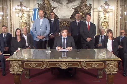 This screen grab obtained from a handout video broadcasted by Argentina's Presidency shows President Javier Milei (C) delivering a message to the nation from the Casa Rosada presidential palace in Buenos Aires on December 20, 2023. Argentina's new leader Javier Milei announced Wednesday that he would proceed with a massive deregulation of the country's economy by presidential decree, eliminating or changing more than 300 rules, including on rent and the right to work. (Photo by Handout / Argentina's Presidency Press Office / AFP) / RESTRICTED TO EDITORIAL USE - MANDATORY CREDIT "AFP PHOTO / ARGENTINA'S PRESIDENCY " - NO MARKETING - NO ADVERTISING CAMPAIGNS - DISTRIBUTED AS A SERVICE TO CLIENTS<!-- NICAID(15631622) -->