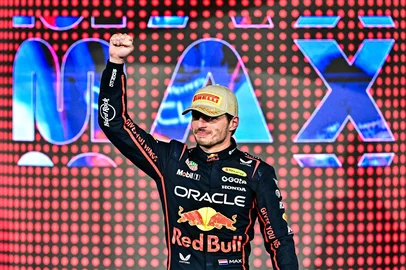 Race winner Red Bull Racing's Dutch driver Max Verstappen celebrates on the podium at the end of the Abu Dhabi Formula One Grand Prix at the Yas Marina Circuit in Abu Dhabi on December 7, 2025. (Photo by Giuseppe CACACE / AFP)<!-- NICAID(16182485) -->