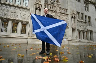A Scottish independence supporter poses with the flag of Scotland outside the Supreme Court in London on November 23, 2022 after the court blocked a new vote on independence. - The UK Supreme Court rejected a bid by the devolved Scottish government in Edinburgh to hold a new referendum on independence without the consent of London. (Photo by Justin TALLIS / AFP)<!-- NICAID(15273377) -->