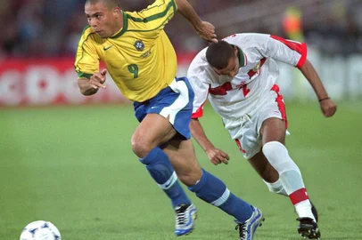 FRANK PERRY / AFP CUP-FR98-BRA-MOR-RONALDOBrazilian forward Ronaldo chases the ball with Moroccan defender Abdelilah Saber 16 June at the Stade de la Beaujoire in Nantes, during the 1998 Soccer World Cup group A first round match between Brazil and Morocco. Brazil won 3-0. AFP PHOTO Frank PERRY (Photo by FRANK PERRY / AFP)Editoria: SPOLocal: NantesIndexador: FRANK PERRYSecao: soccerFonte: AFPFotógrafo: STF<!-- NICAID(16305642) -->