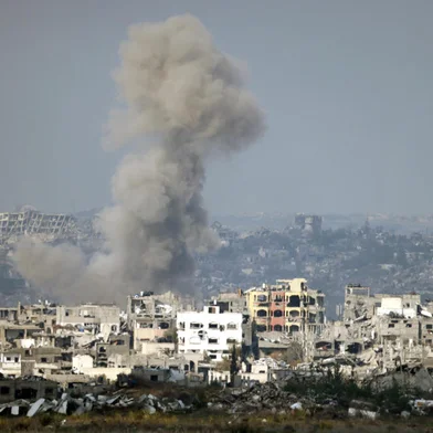 This picture taken from the Israeli side of the border with the Gaza Strip shows smoke plumes rising from explosions above destroyed buildings in the northern Gaza Strip on January 16, 2025, following the announcement of a truce amid the ongoing war between Israel and Hamas. (Photo by Menahem KAHANA / AFP)<!-- NICAID(15954781) -->