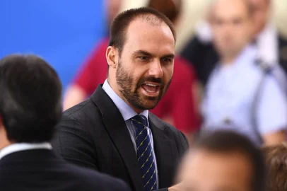 (FILES) In this file photo taken on April 17, 2020, Brazilian Deputy Eduardo Bolsonaro, son of Brazilian President Jair Bolsonaro, gestures during the swearing-in ceremony of Brazil's new Health Minister Nelson Teich (out of frame) at Planalto Palace in Brasilia. - A Brazilian court on January 21, 2021 ordered Congressman Eduardo Bolsonaro to compensate a journalist for moral damages for claiming that he "tried to seduce" a person to obtain damaging information against his father, President Jair Bolsonaro. (Photo by EVARISTO SA / AFP)<!-- NICAID(14701219) -->