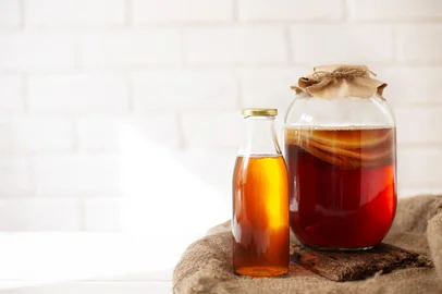 Glass jar with komucha scoby and bottle of ready beverage on light backgroundGlass jar with komucha scoby and bottle of ready beverage on light bricked background with copy space. Healthy fermented drink. Foto: Top Stock Photos / stock.adobe.comFonte: 425876065<!-- NICAID(16114874) -->