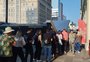 Passageiros formam longa fila à espera de ônibus após fechamento de estações da Trensurb por conta da cheia