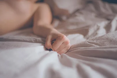 Hand sign orgasm of woman on white bed. Hand of female pulling white sheets in ecstasy. Feeling and emotion concept. Love sex concept.Indexador: Nikonov DanilFonte: 265764173<!-- NICAID(15571407) -->