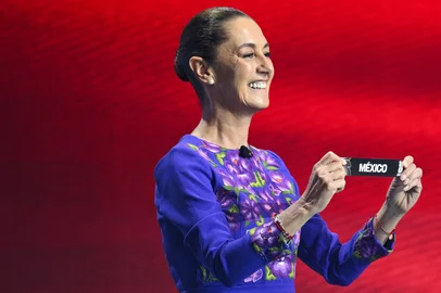 Mexico's President Claudia Sheinbaum shows the card reading Mexico during the draw for the 2026 FIFA Football World Cup taking place in the US, Canada and Mexico, at the Kennedy Center, in Washington, DC, on December 5, 2025. (Photo by SAUL LOEB / AFP)Editoria: SPOLocal: WashingtonIndexador: SAUL LOEBSecao: soccerFonte: AFPFotógrafo: STF<!-- NICAID(16181209) -->