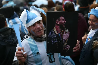 A fan holding a portrait of Argentina's forward Lionel Messi gathers near the Argentine Football Association (AFA) training camp in Ezeiza, Buenos Aires Province, on July 20, 2026, while waiting for the arrival of Argentina's national football team from the United States following its defeat in the 2026 FIFA World Cup final. (Photo by Luis ROBAYO / AFP)<!-- NICAID(16330673) -->