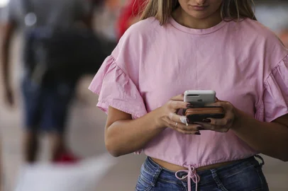 Porto Alegre, RS, Brasil, 28-12-2023: Mulher utiliza celular nas imediações da Esquina Democrática. Polícia militar dá dicas de segurança para quem circula a pé ou utiliza transporte coletivo na região central no período em que a cidade costuma estar mais vazia. Entre condutas de risco, que devem ser evitadas: uso do celular, fones de ouvido, mochilas nas costas. Foto: Mateus Bruxel / Agência RBSIndexador: Mateus Bruxel<!-- NICAID(15636310) -->
