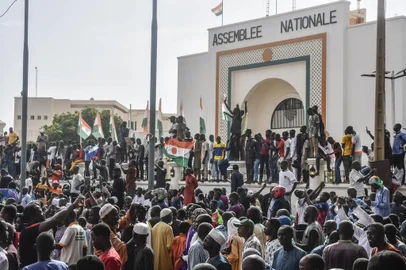 Supporters wave Nigerien's flags as they rally in support of Niger's junta in front of the National Assembly in Niamey on July 30, 2023. Niger's junta on Sunday said ECOWAS could stage an imminent military intervention in the capital Niamey as the regional body meets for an "extraordinary summit" on the coup-hit country, with sanctions a possibility. The country's elected president Mohamed Bazoum has been held by the military for four days, and General Abdourahamane Tiani, the chief of the powerful presidential guard, has declared himself leader. (Photo by AFP)<!-- NICAID(15496053) -->