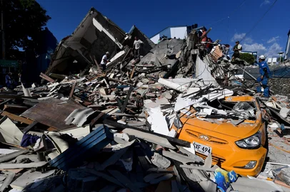 JAIME SALDARRIAGA / AFP Rescuers look for survivors amid the rubble of a collapsed building and a damaged taxi after an earthquake in Pereira, Colombia on August 10, 2026. A powerful earthquake rocked Colombia and neighboring Latin American countries on August 10, 2026, with medical teams rushing to help victims after buildings were damaged or collapsed in several cities. The Colombian geological service and its American counterpart USGS put the magnitude at 7.4, with an epicenter 100 km (60 miles) underground in the west of the country. Colombia had initially put it at 6.6. (Photo by Jaime SALDARRIAGA / AFP)<!-- NICAID(16343872) -->