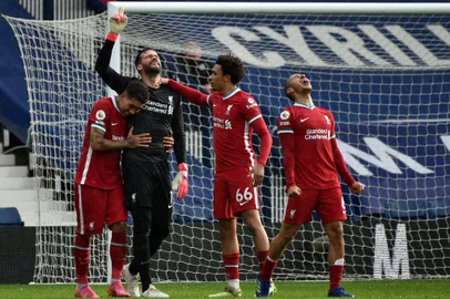 Liverpool's Brazilian goalkeeper Alisson Becker (2L) celebrates scoring his team's second goal with teammates during the English Premier League football match between West Bromwich Albion and Liverpool at The Hawthorns stadium in West Bromwich, central England, on May 16, 2021. (Photo by Rui Vieira / POOL / AFP) / RESTRICTED TO EDITORIAL USE. No use with unauthorized audio, video, data, fixture lists, club/league logos or 'live' services. Online in-match use limited to 120 images. An additional 40 images may be used in extra time. No video emulation. Social media in-match use limited to 120 images. An additional 40 images may be used in extra time. No use in betting publications, games or single club/league/player publications. / <!-- NICAID(14784441) -->