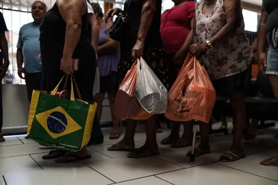 SÃO LEOPOLDO, RS, BRASIL, 16-12-2025: Expectativa para o natal em meio a fome. 1,5 milhão de pessoas enfrentam insegurança alimentar no Rio Grande do Sul.  Desde 2021, a Cozinha Solidária Marielle Franco, serve cerca de 270 almoços por dia, em dois dias da semana, atendendo a comunidade de Arroio Manteiga, em São Leopoldo. A população leva seus recipientes para buscar as refeições de cardápio variado. Foto: Renan Mattos / Agência RBS<!-- NICAID(16188803) -->