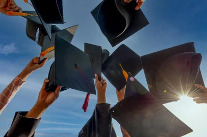 Graduates throwing graduation hats Up in the skyGraduados jogando chapéus de formatura. Foto: mnirat / stock.adobe.comIndexador: Photographer_Nirat.pix@gmail.comFonte: 412215187<!-- NICAID(15239155) -->