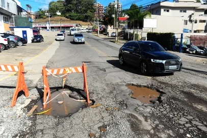 CAXIAS DO SUL, RS, BRASIL, 14/07/2023. Após chuvas intensas, Caxias do Sul registra estragos nas ruas. Na foto, dois buracos apareceram na rua Nestor Carlos Fedrizzi próximo da rótula com a perimetral Norte. (Porthus Junior/Agência RBS)<!-- NICAID(15483086) -->