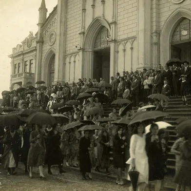 Dia 7 de abril de 1930: o cortejo fúnebre do menino Vasco Fochesato, o Vasquinho, saindo da Igreja Matriz Santa Teresa (Catedral, ainda com as escadarias frontais) em direção ao Cemitério Público Municipal de Caxias do Sul.<!-- NICAID(15252426) -->