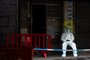 A police officer wearing a protective gear guards the entrance of the  building were a resident tested positive for Covid-19 in Macau on November 1, 2022. (Photo by Eduardo Leal / AFP)<!-- NICAID(15253921) -->